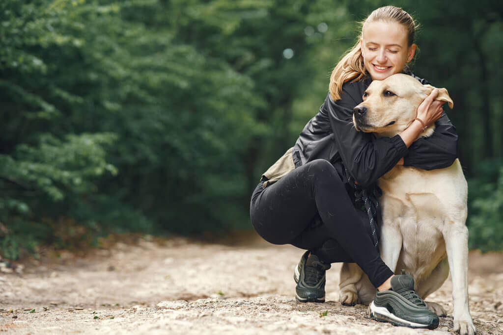 Mujer abrazando a hermoso perro labrador